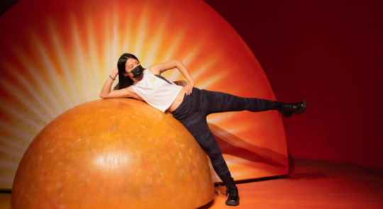 女生在天文館的地球核心前拍照