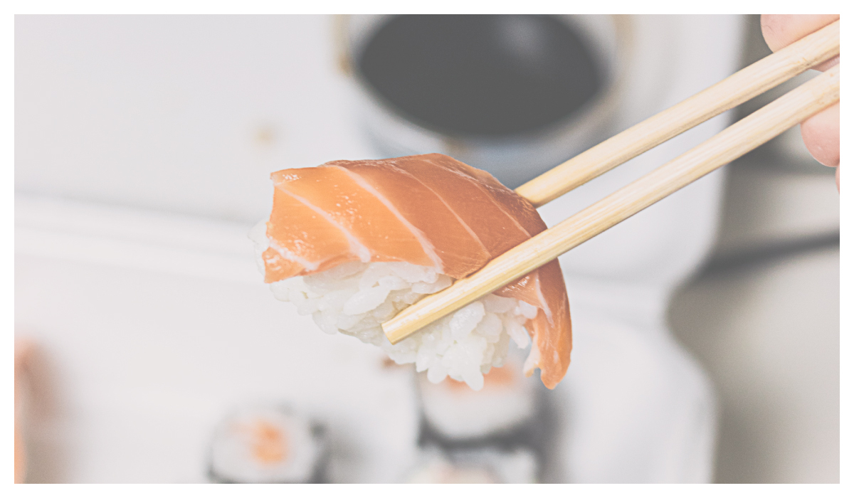 用筷子夾鮭魚握壽司