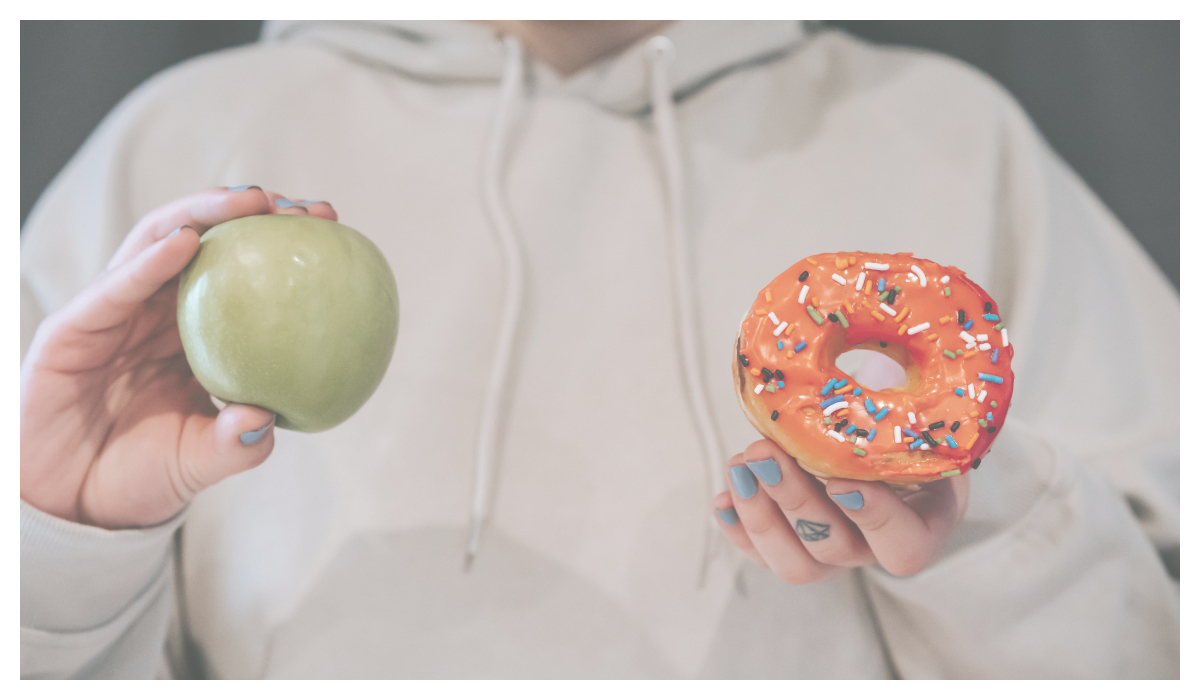 一個女生拿著青蘋果跟甜甜圈