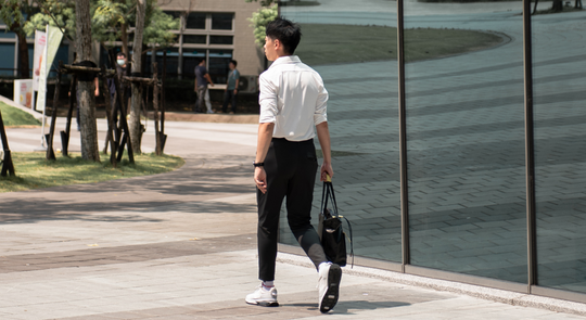 男生著白襯衫與黑西裝褲 準備進公司上班