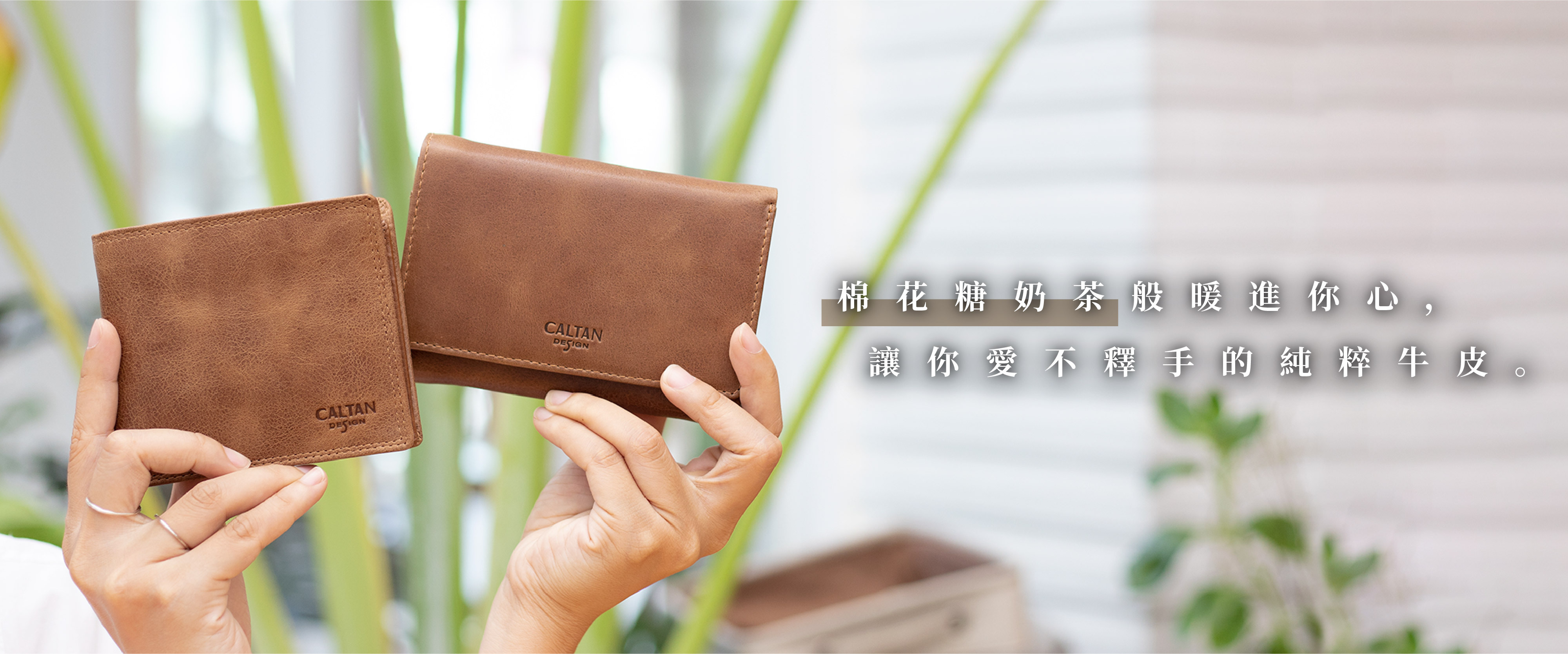 手裡拿著兩個霧面奶茶色皮夾