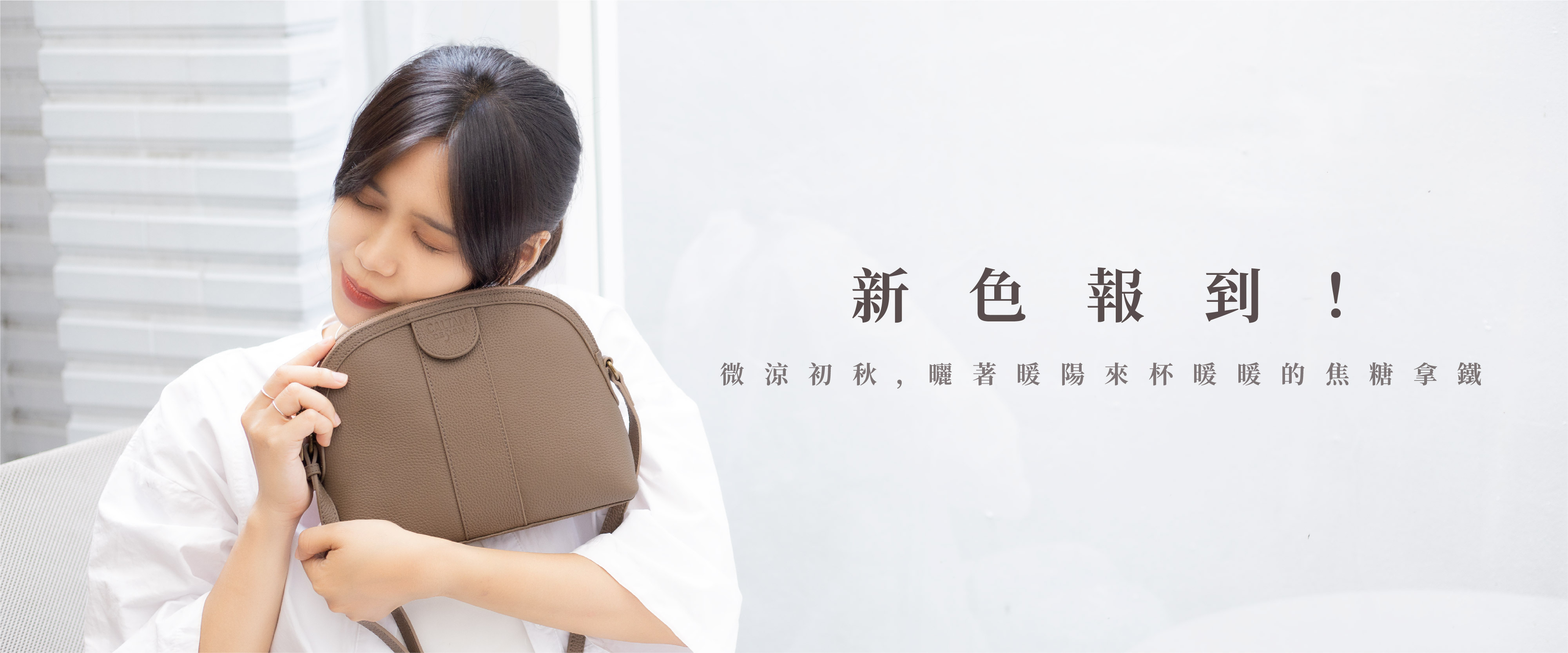 女生抱著一個焦糖拿鐵色小包，很愛惜它的樣子