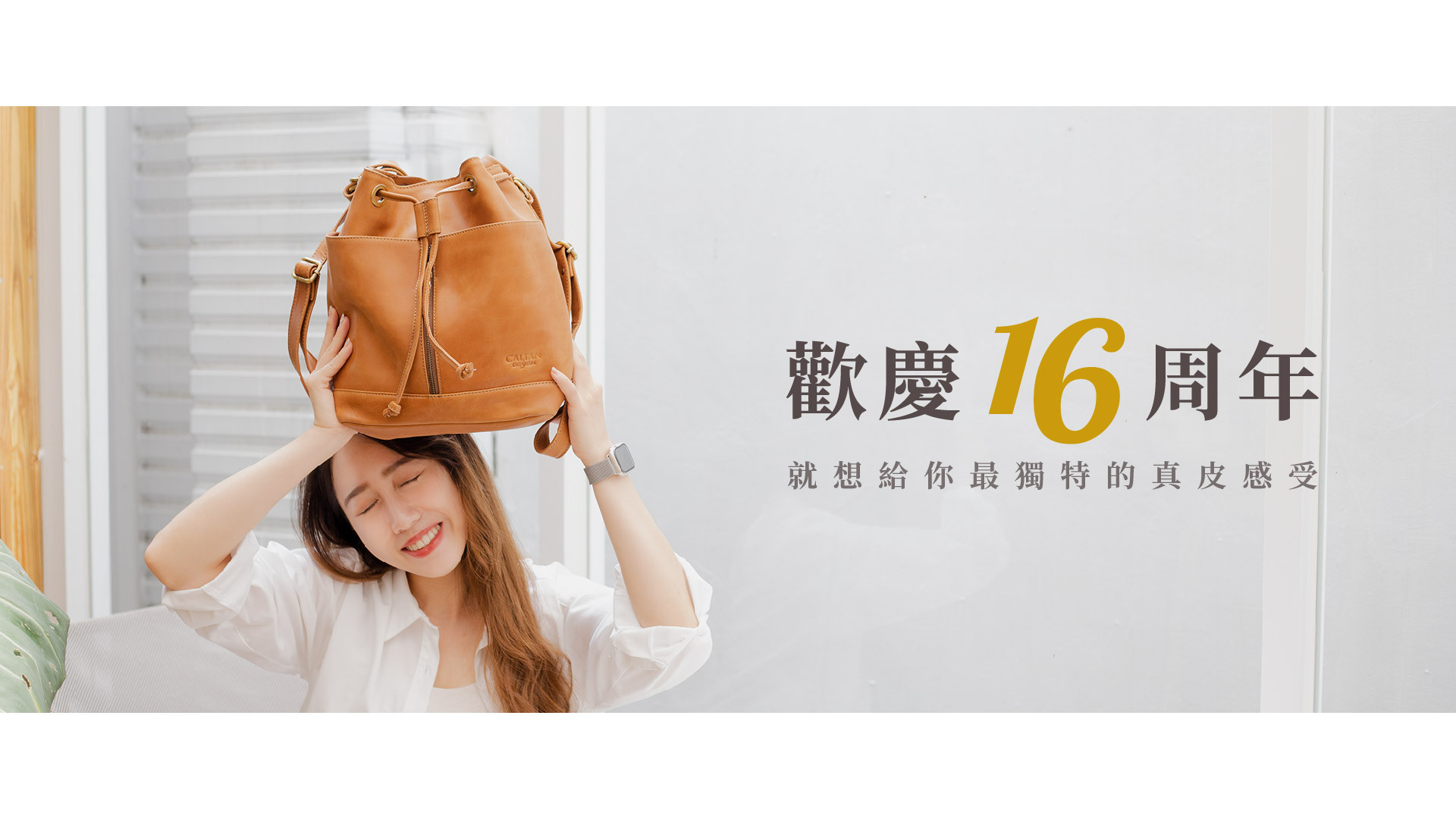 白衣女生舉起褐色包包,歡慶16周年,白色背景