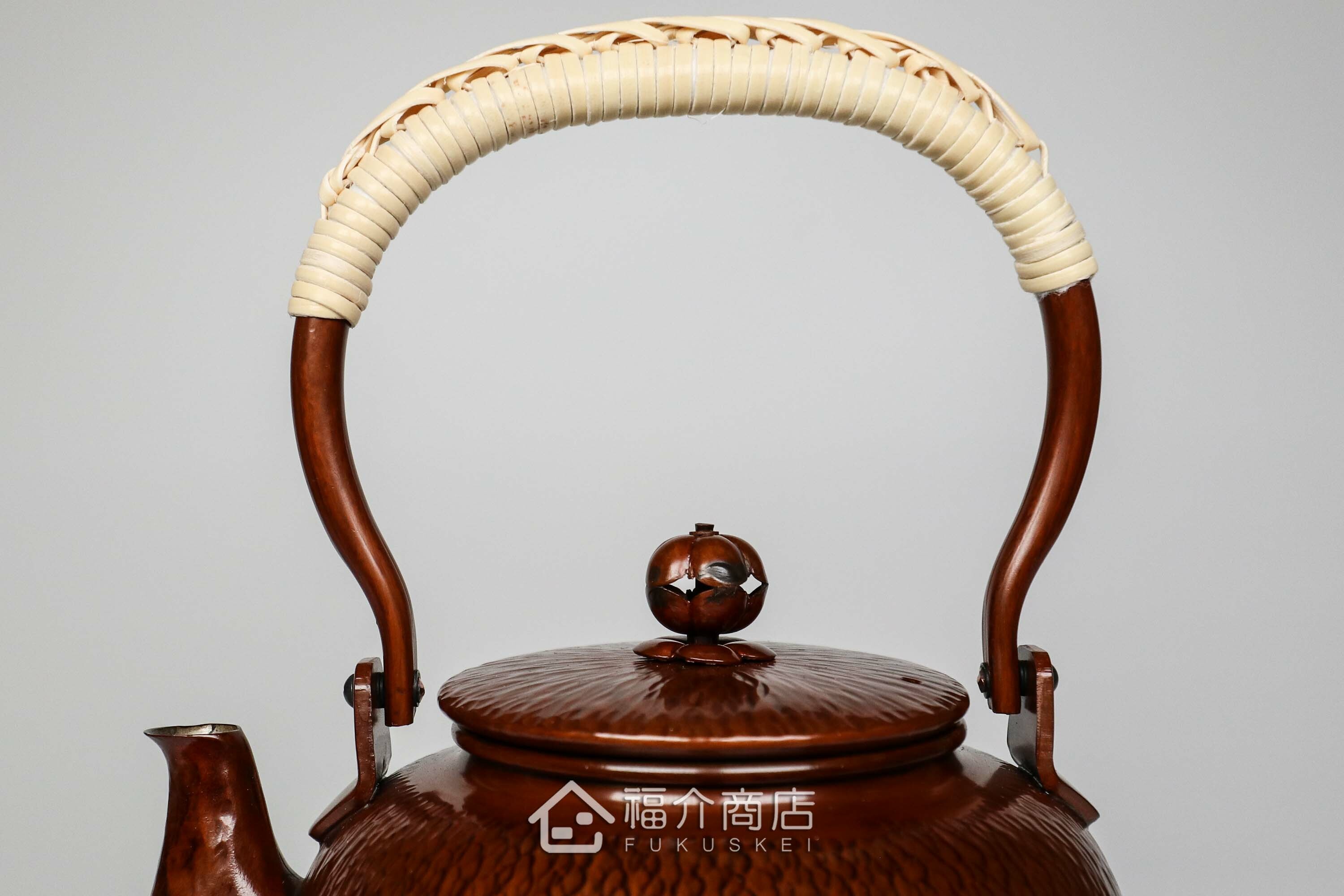 編織提樑造型的咖啡色銅壺