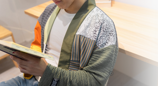 穿著拼接罩衫的男生在看書