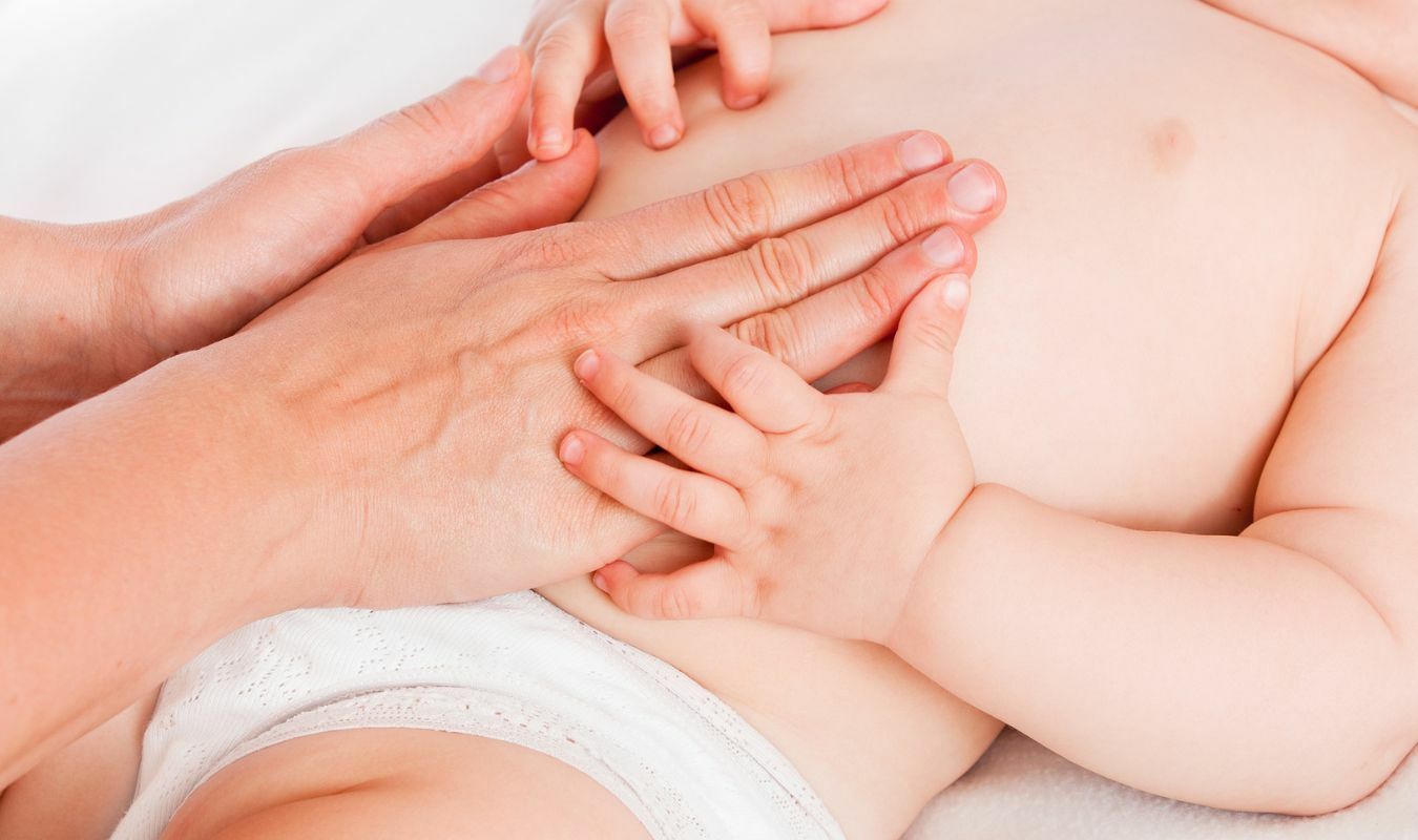 手貼在寶寶腹部進行按摩的畫面｜逗DOLL SPA好孕寶寶純淨按摩油