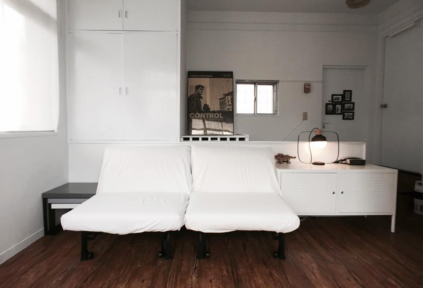 文青風格的空間，四百擊的電影海報，收納櫃上擺放了一個桌燈。