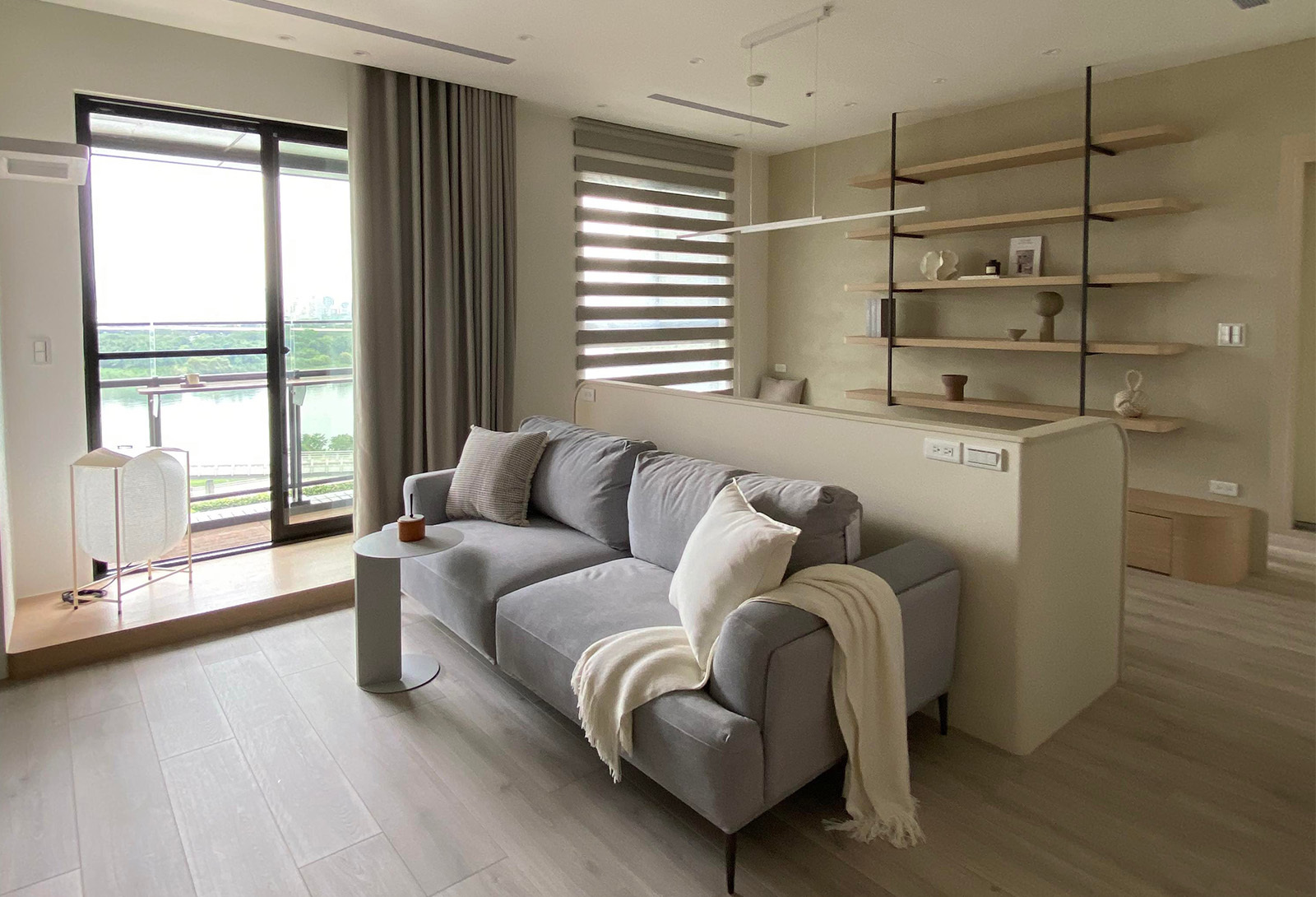 一個燈籠造型的地燈，在沙發旁，整體空間呈現韓式奶油風格。