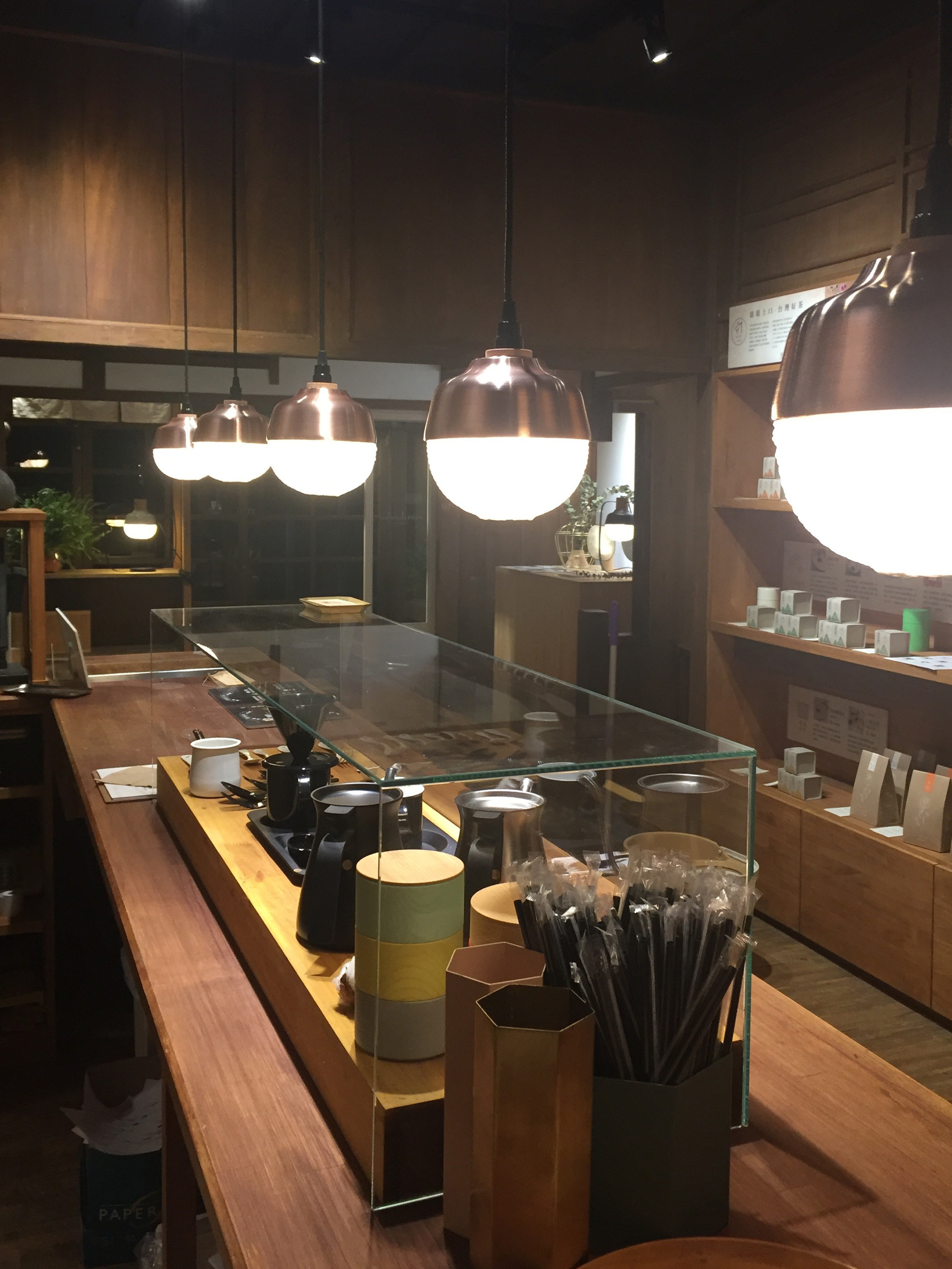 日式百年檜木老屋中吊掛著數盞紅銅燈罩結合紙燈籠造型的吊燈