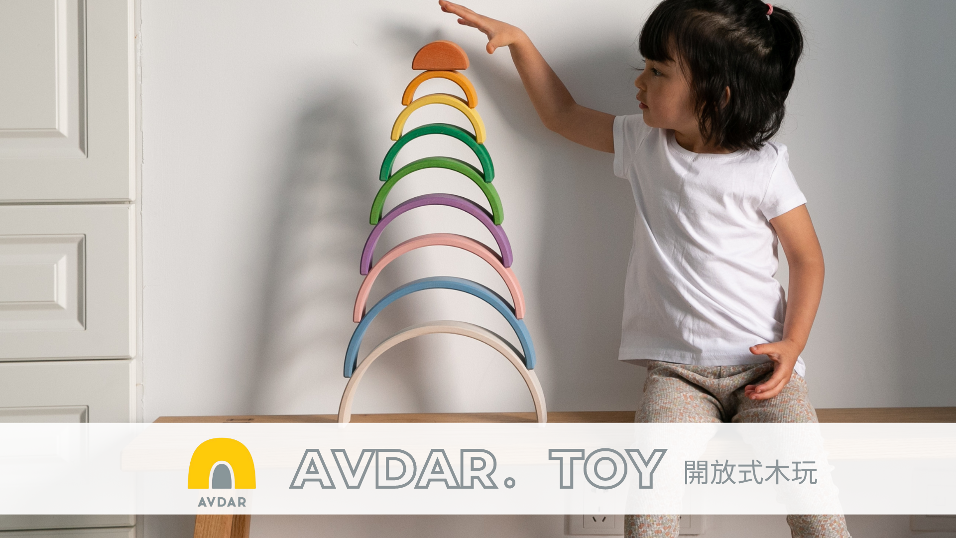 小女孩在用彩虹積木搭房子