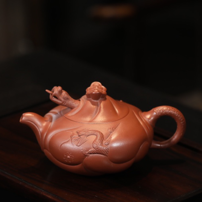 【魚化龍】--壺鈕為卷雲狀，壺身淺塑波浪，波浪中龍伸出首部，龍尾捲成壺把，把上鱗片刻劃清晰