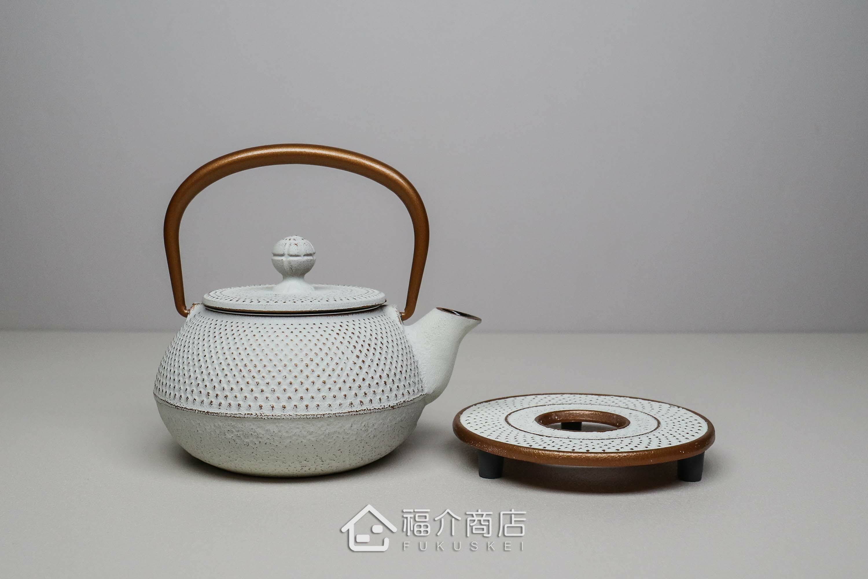 泡茶用的白色鐵壺金色提把