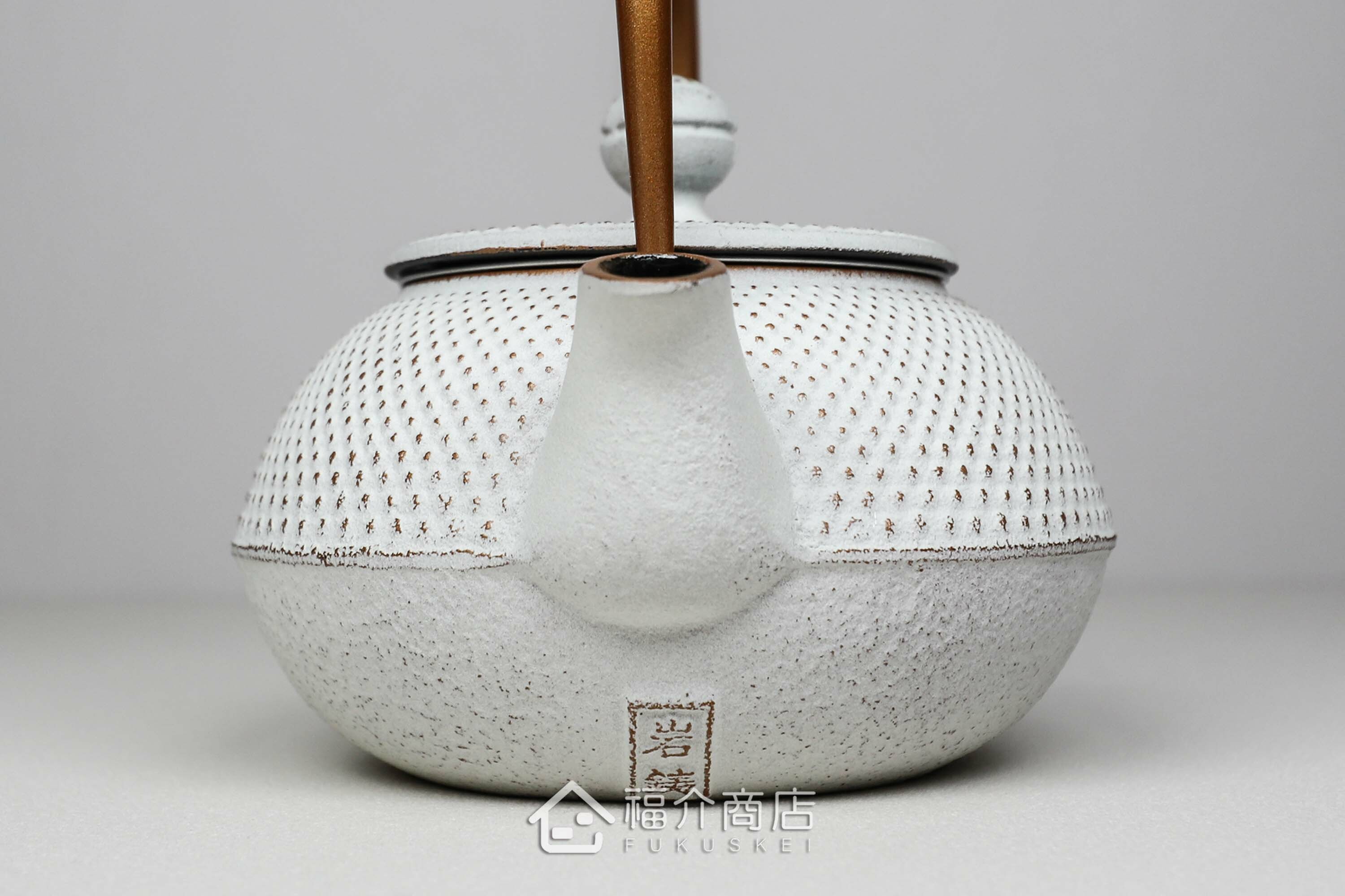 泡茶用的白色鐵壺金色提把