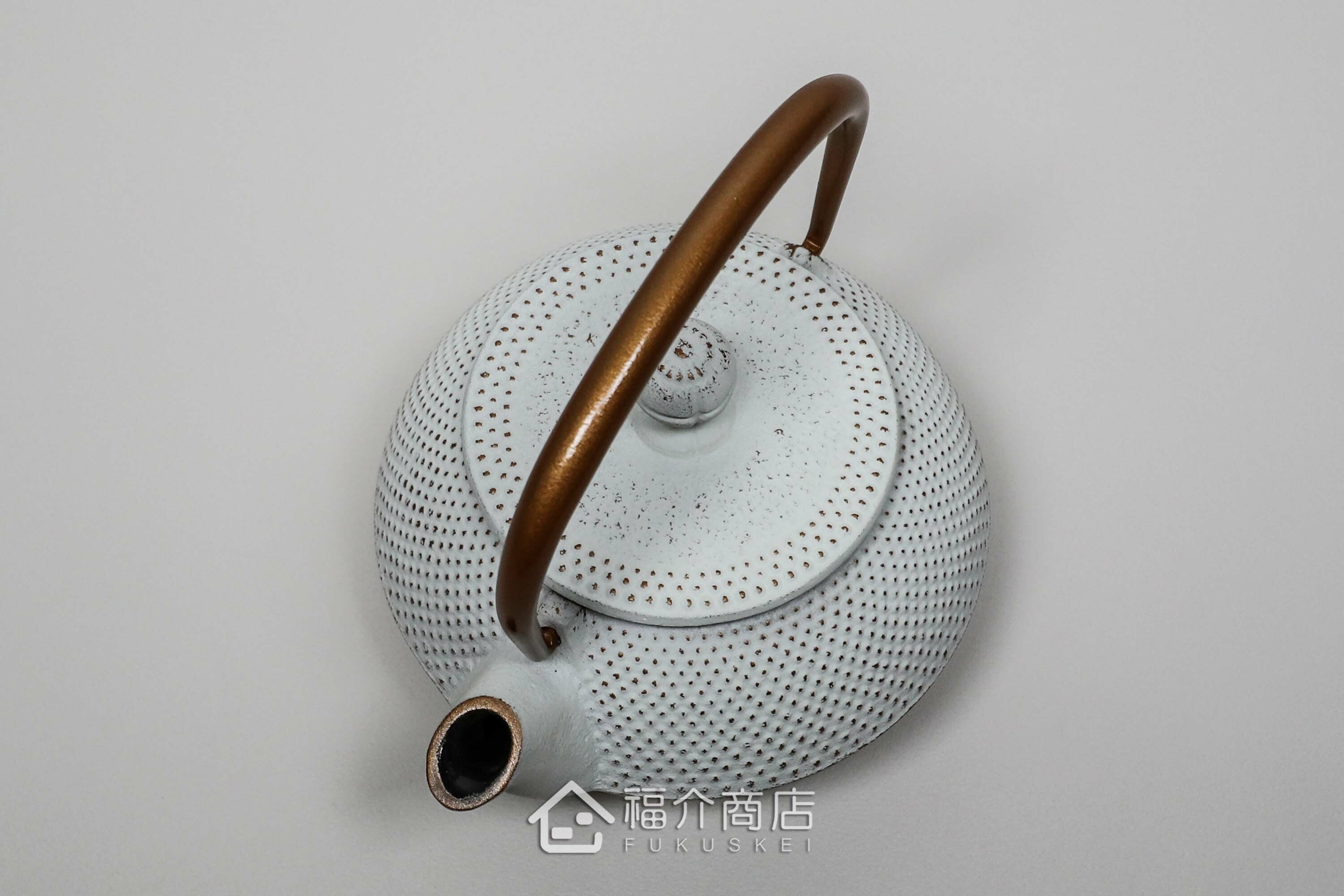 泡茶用的白色鐵壺金色提把