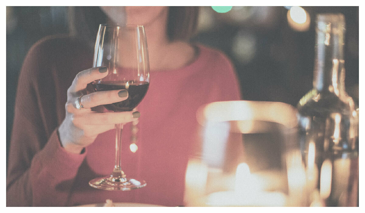 一個女人拿著一杯紅酒