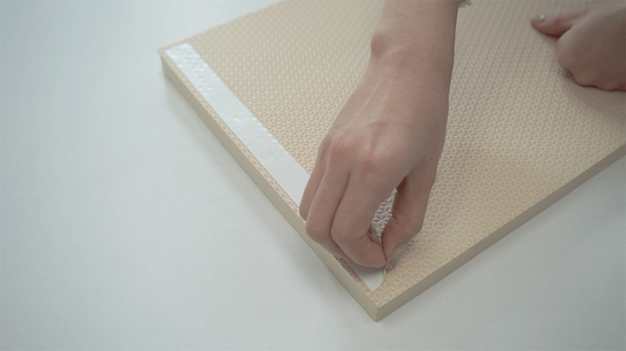 黏好雙面膠後，將其重壓、刮壓，並撕下雙面膠