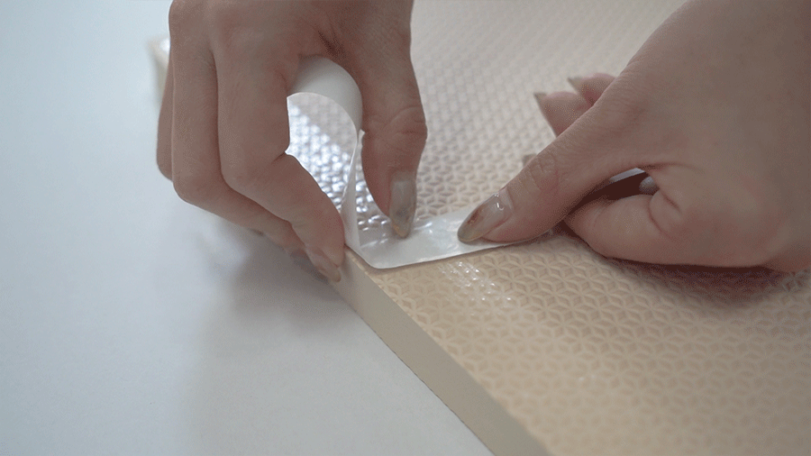 用撕下來的雙面膠表皮，再一次反覆刮/壓壁貼，使紋路黏得更深