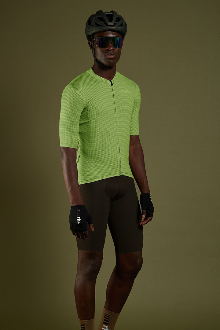 專業模特兒身穿綠色SUPER LIGHT系列極輕量級專業自行車衣加咖啡色TOUS TERRAIN系列專業級自行車褲,頭上戴著安全帽戴著運動眼鏡,戴著單車手套展示穿搭