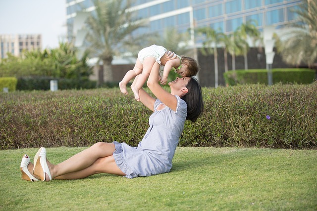 女人和嬰兒在草地上玩耍。