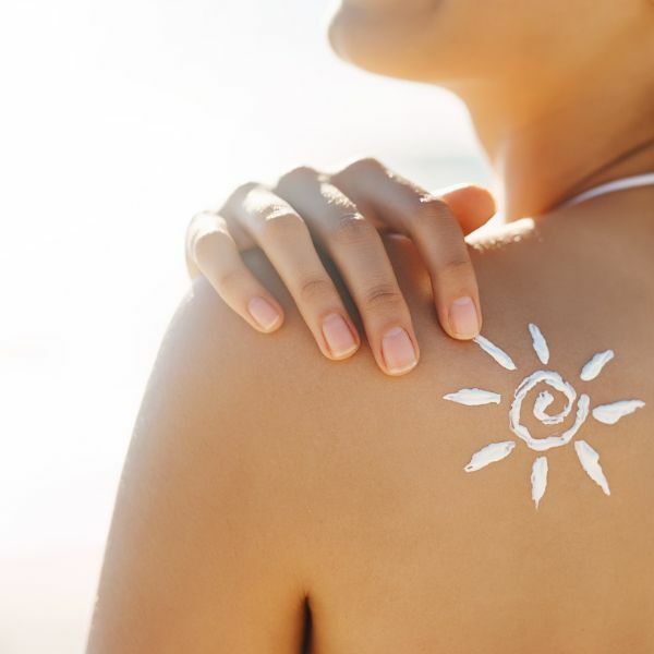 女子的背後用防曬乳液畫出一個太陽的形狀
