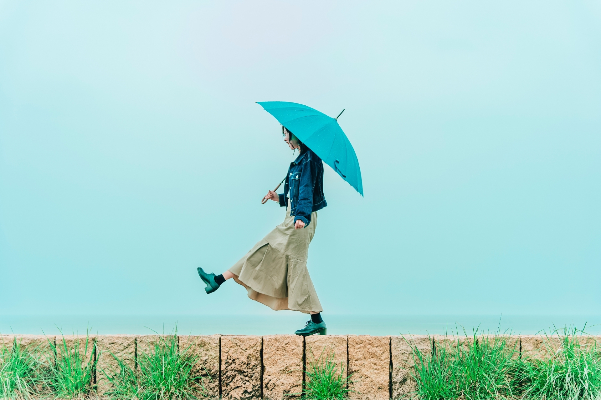 一個女性撐著藍色的雨傘