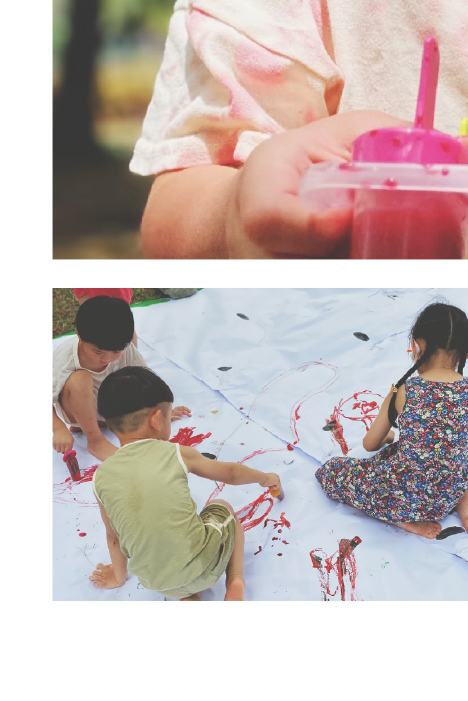 小青山舉辦的親子活動-孩子在草地上用白紙畫畫