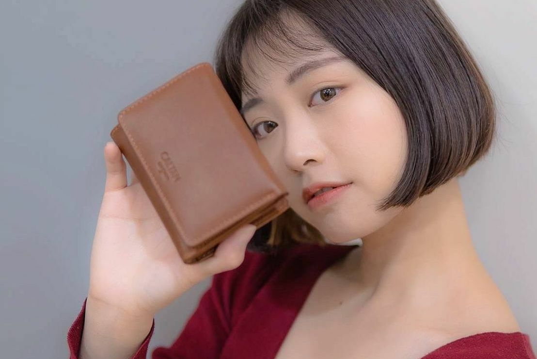 少女手拿真皮短夾