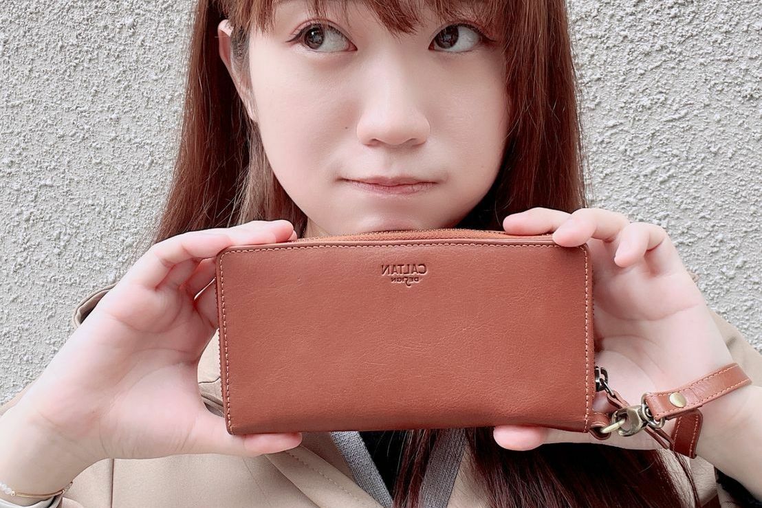 少女手裡拿著真皮長夾
