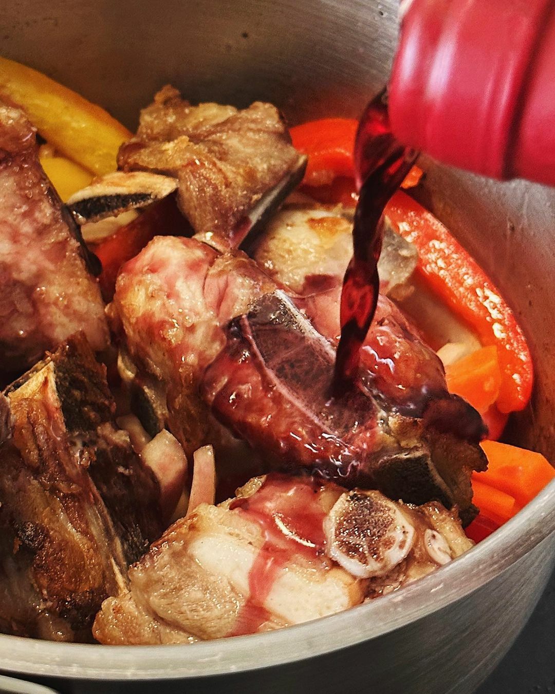 ④把排骨放回鍋中，加入紅酒、月桂葉、伍斯特醬，如果沒有蓋到食材的話就加水至淹過食材