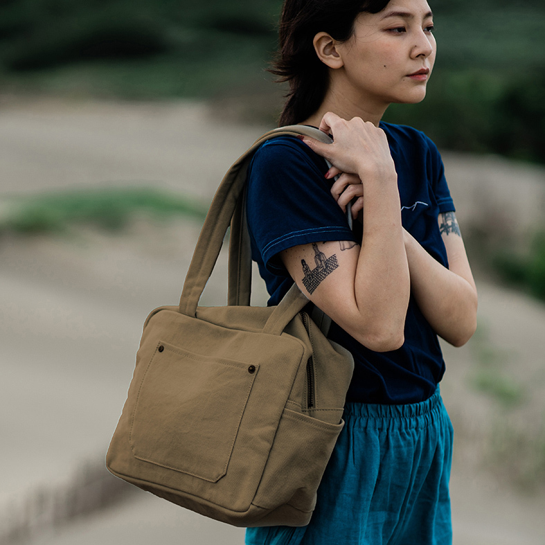 褐土色小款帆布旅行包，Have a Nice Day ，正面具備大容量口袋與方正輪廓