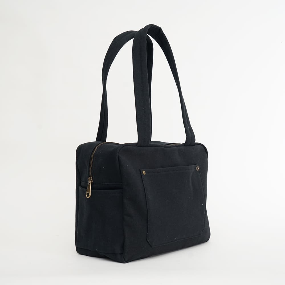 黑色小款帆布旅行包，方形設計，適合日常通勤使用