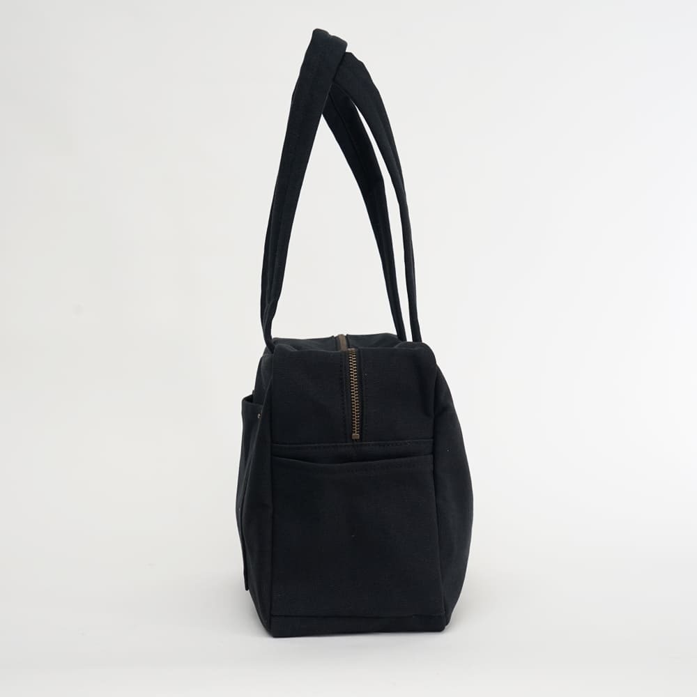黑色小款帆布旅行包，方形設計，適合日常通勤使用