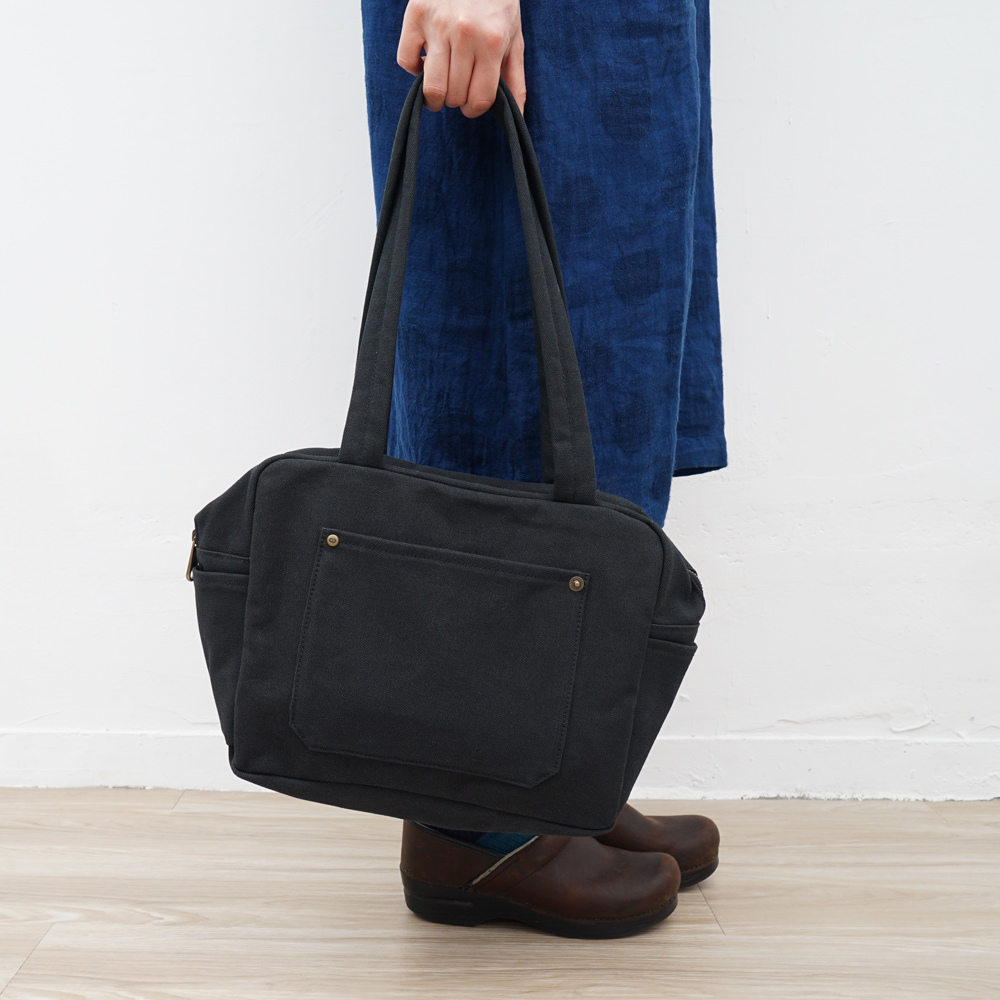 黑色小款帆布旅行包，方形設計，適合日常通勤使用
