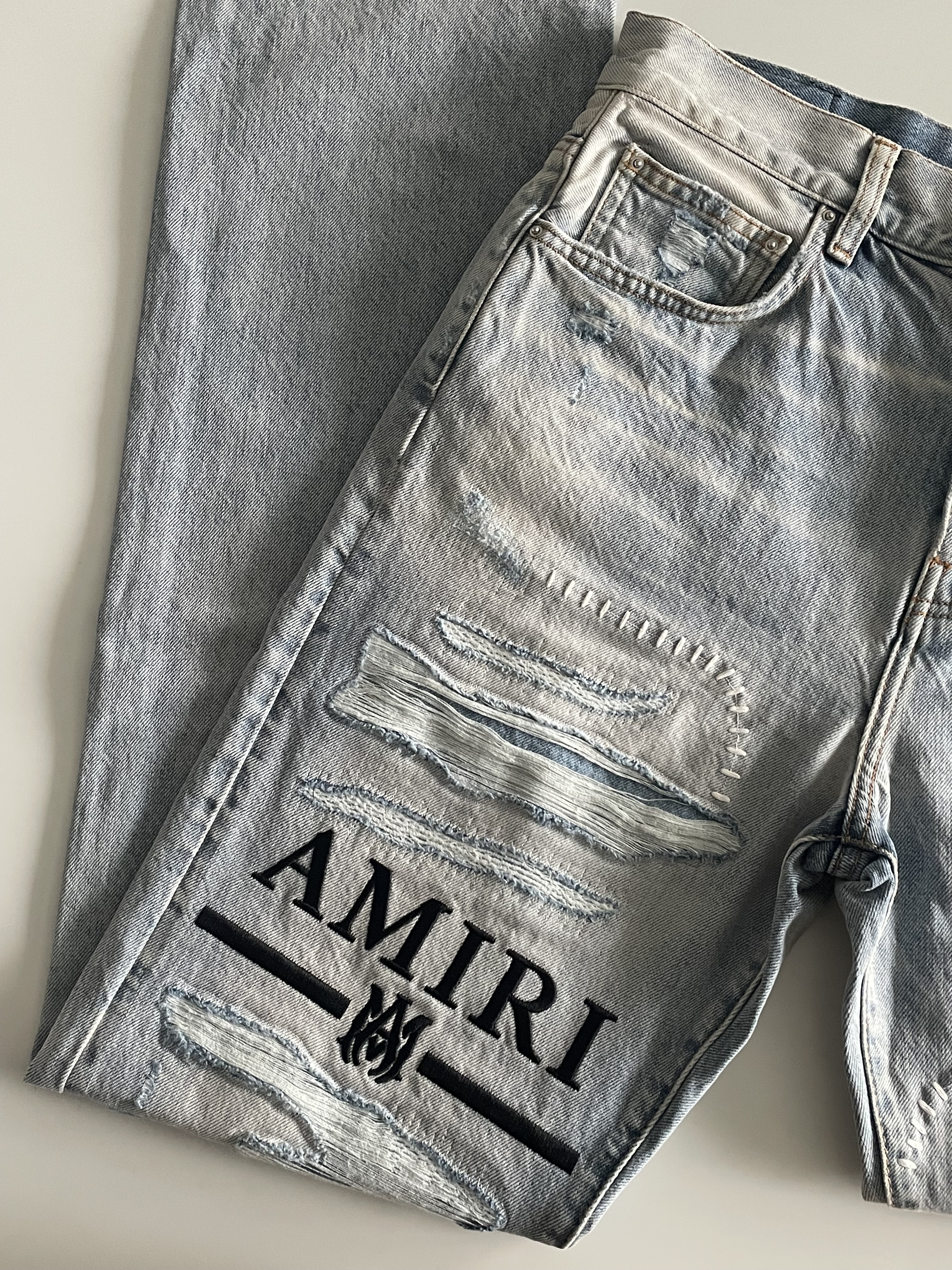 AMIRI 淺色刷微破造型LOGO 牛仔褲