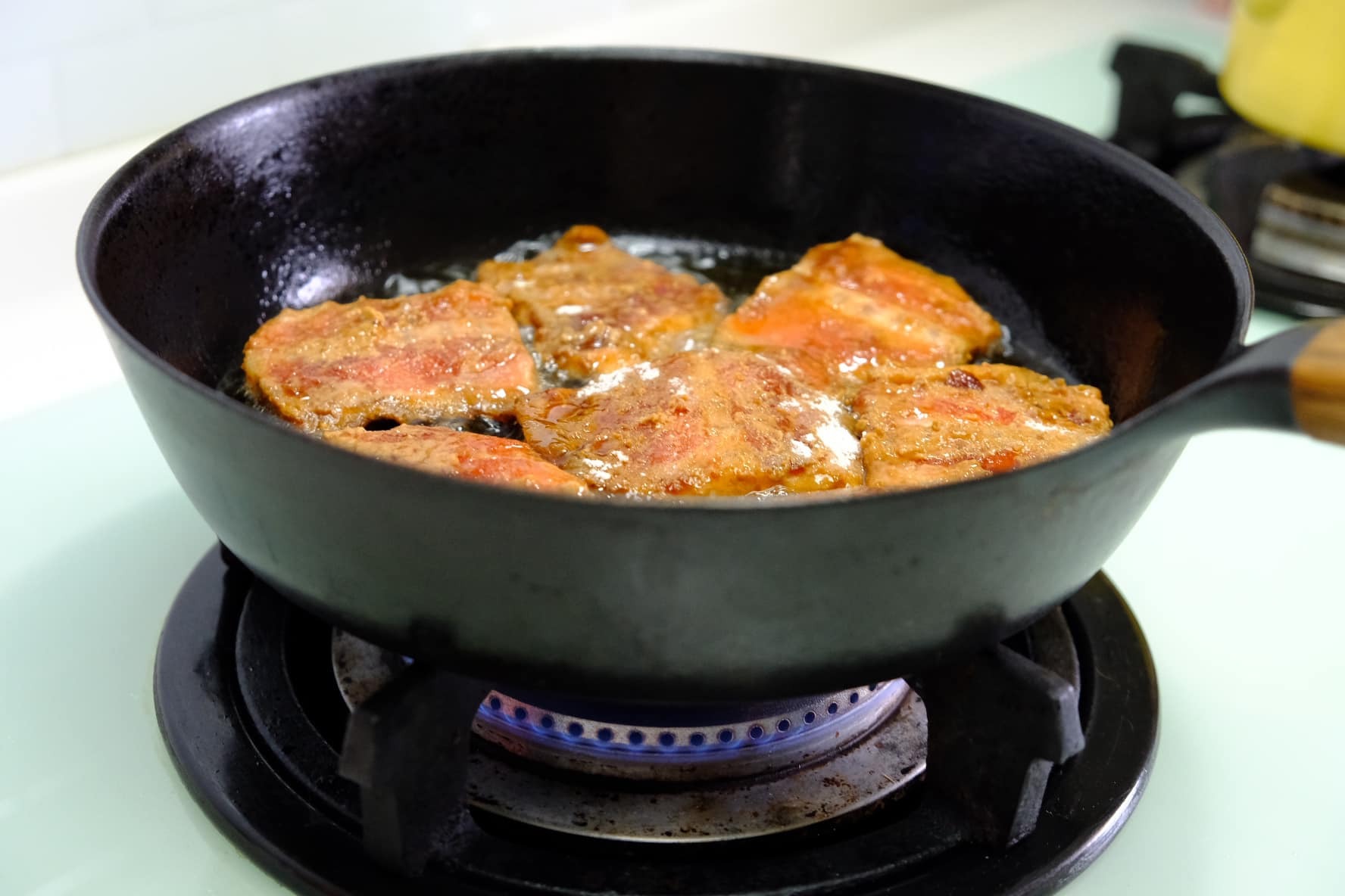 3.少許麵粉入鍋測試油溫、冒小泡泡之後表示油溫夠熱、此時請轉小火。將步驟2的鮭魚骨下鍋小火慢慢炸到金黃色即可。