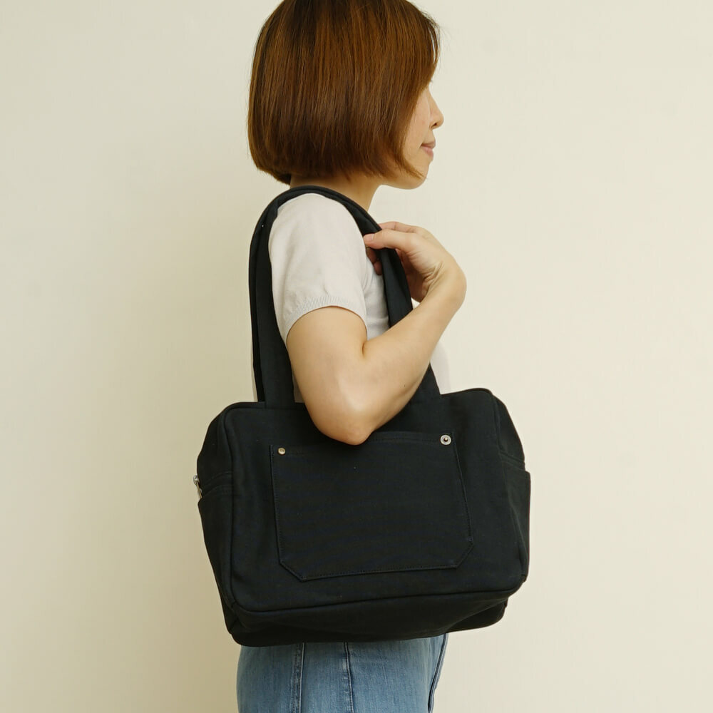 黑色小款帆布旅行包，方形設計，適合日常通勤使用