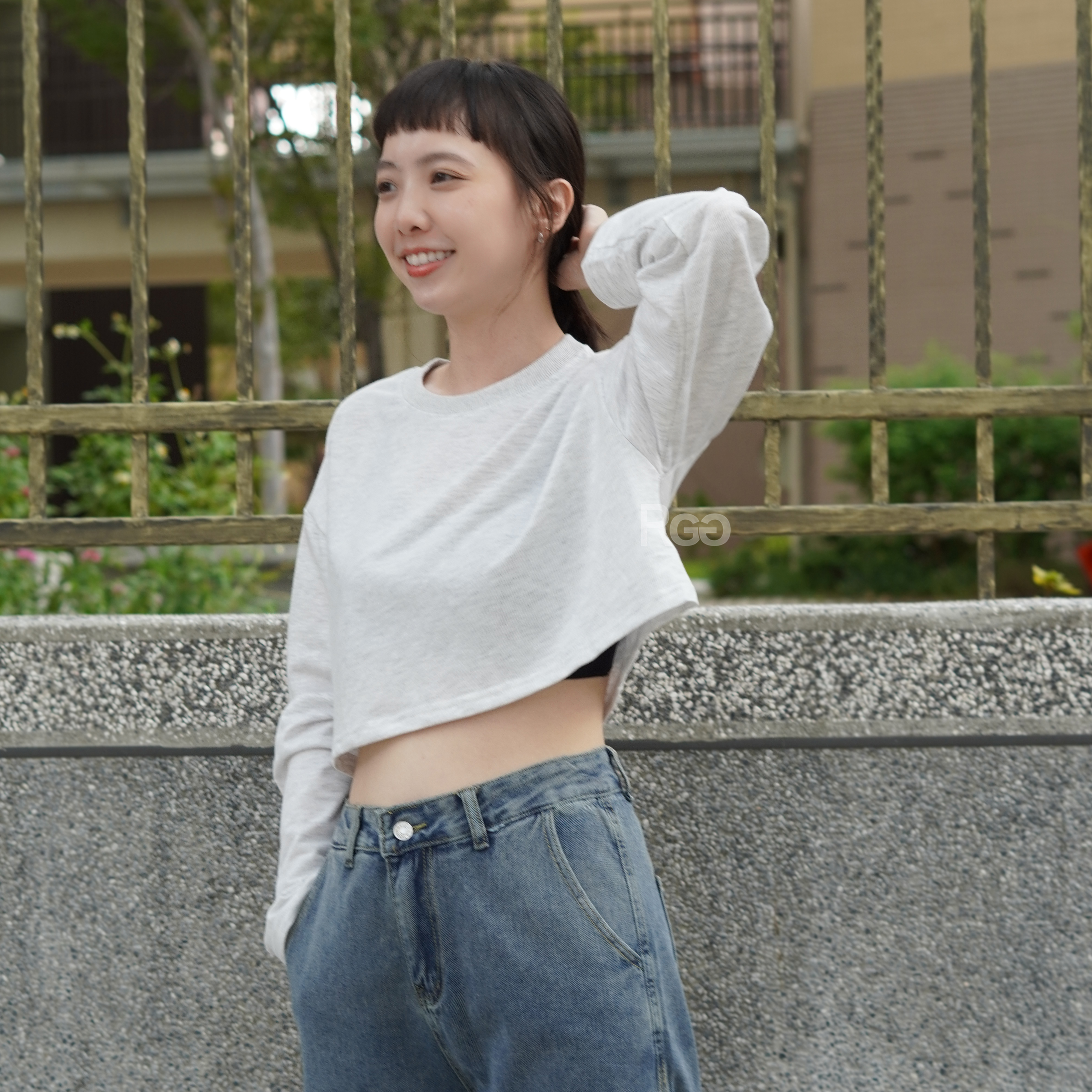 女模著韓版莫蘭迪色系素面短版長T麻白色穿搭