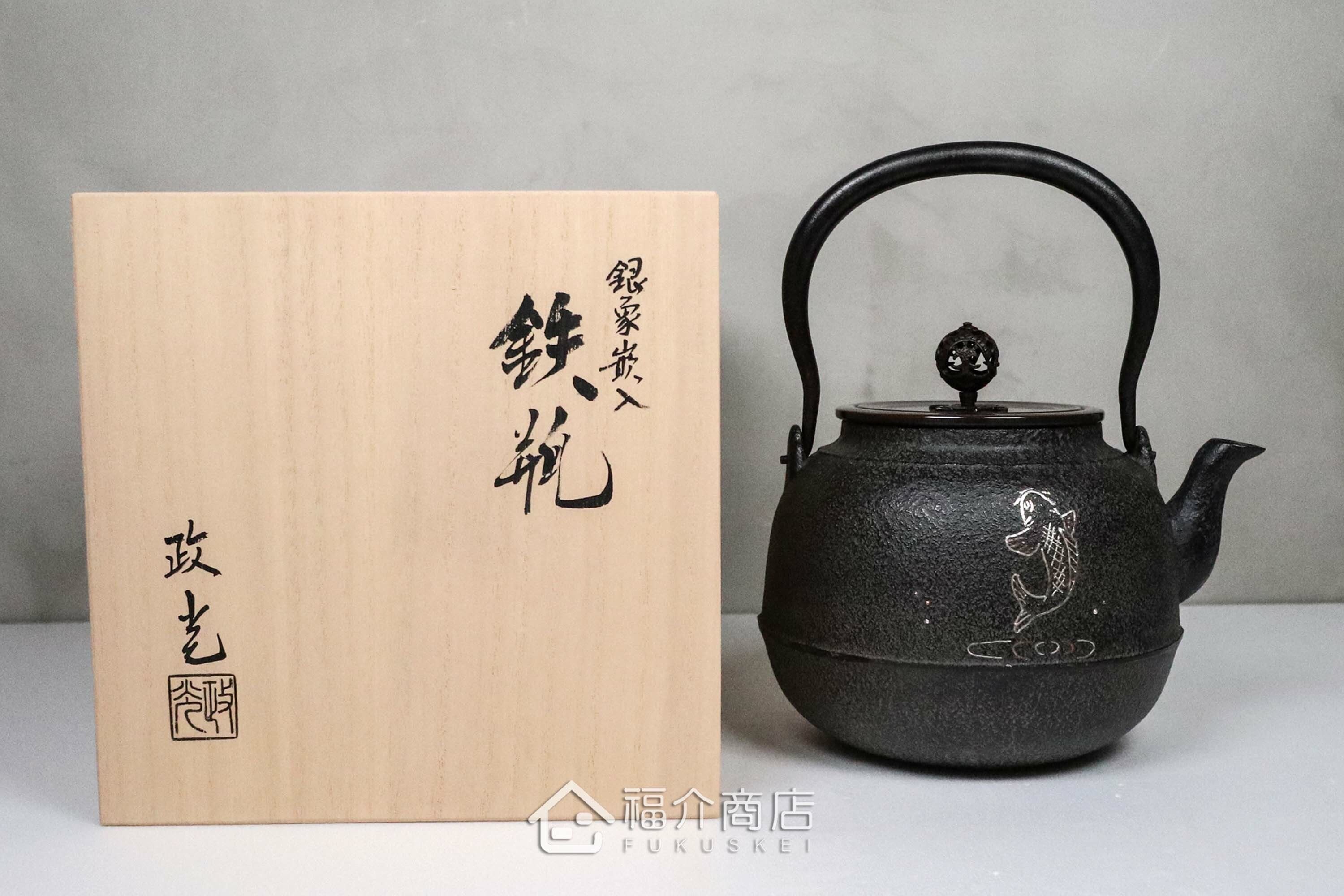 煮水泡茶用的銅蓋鐵壺，壺身象嵌鯉魚紋，木盒包裝