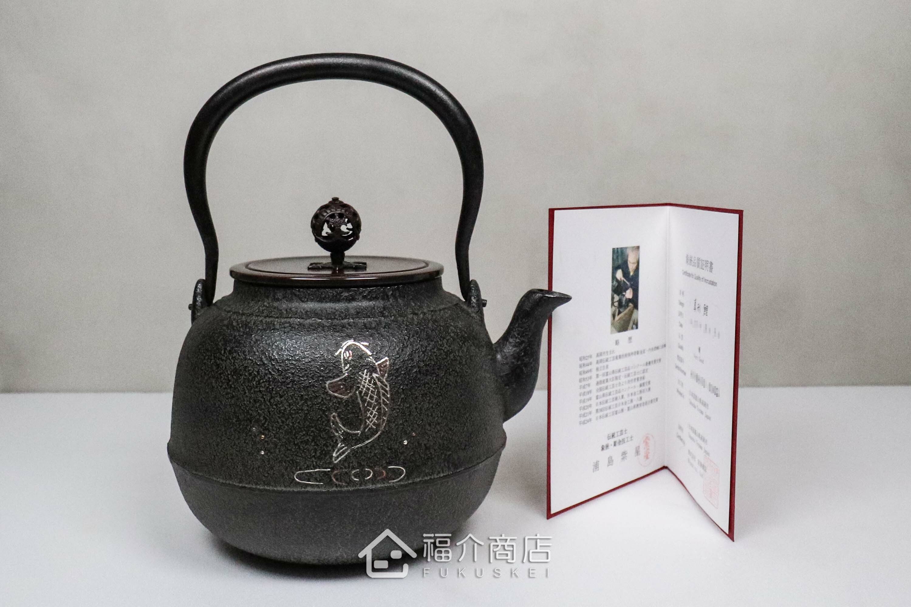 煮水泡茶用的銅蓋鐵壺，壺身象嵌鯉魚紋，附作者證書