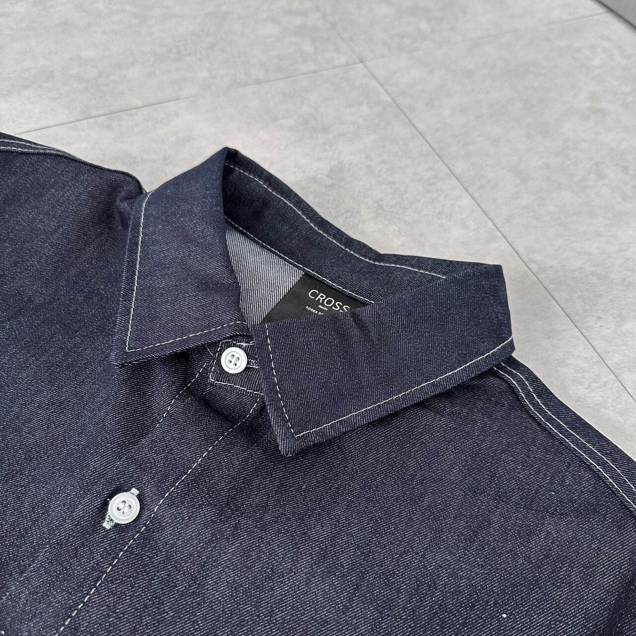藍色丹寧車縫線牛仔襯衫衣領細節照