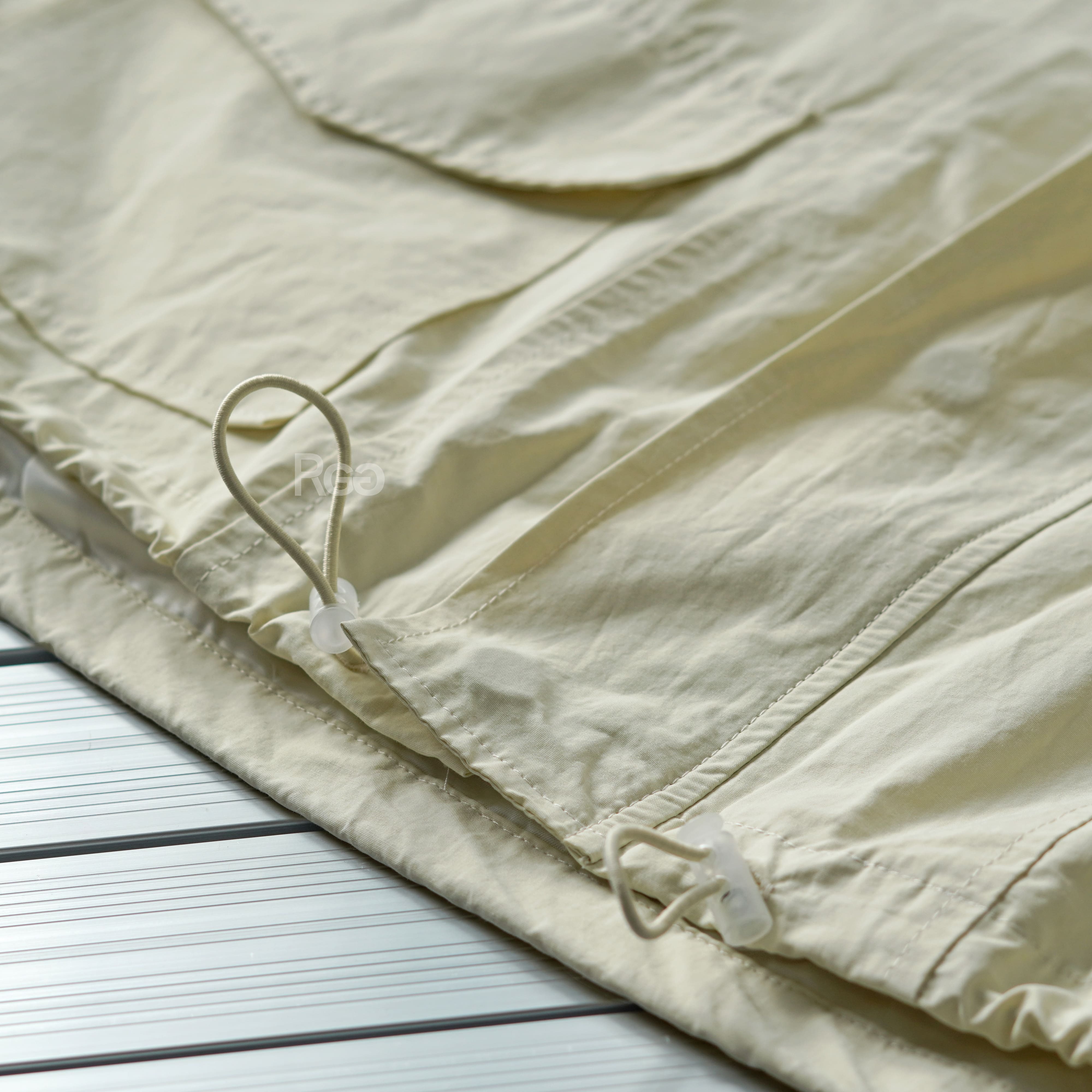 杏色下擺抽繩短版風衣外套下擺細節照