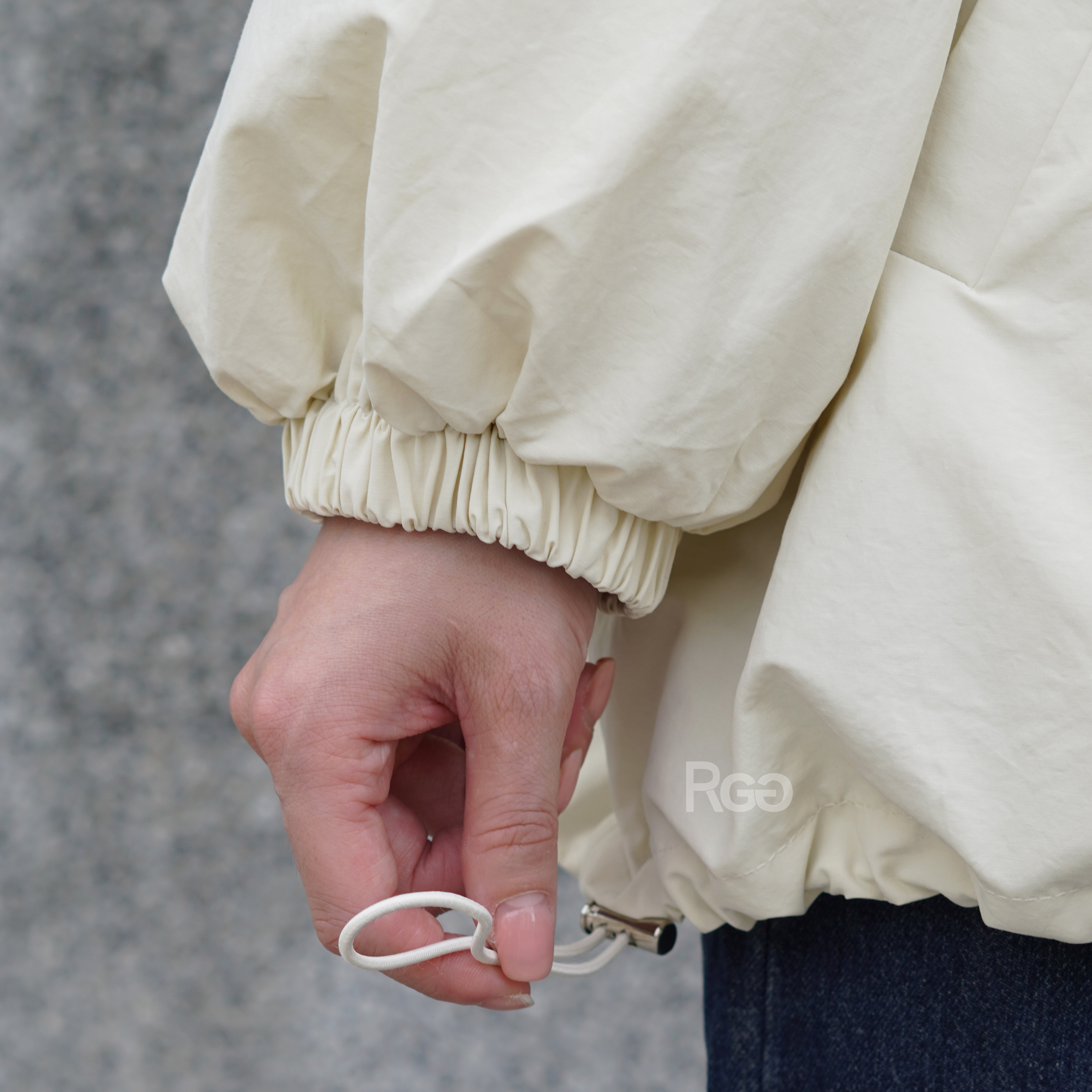 女模穿著寬版風衣拉鍊外套米色下擺細節照