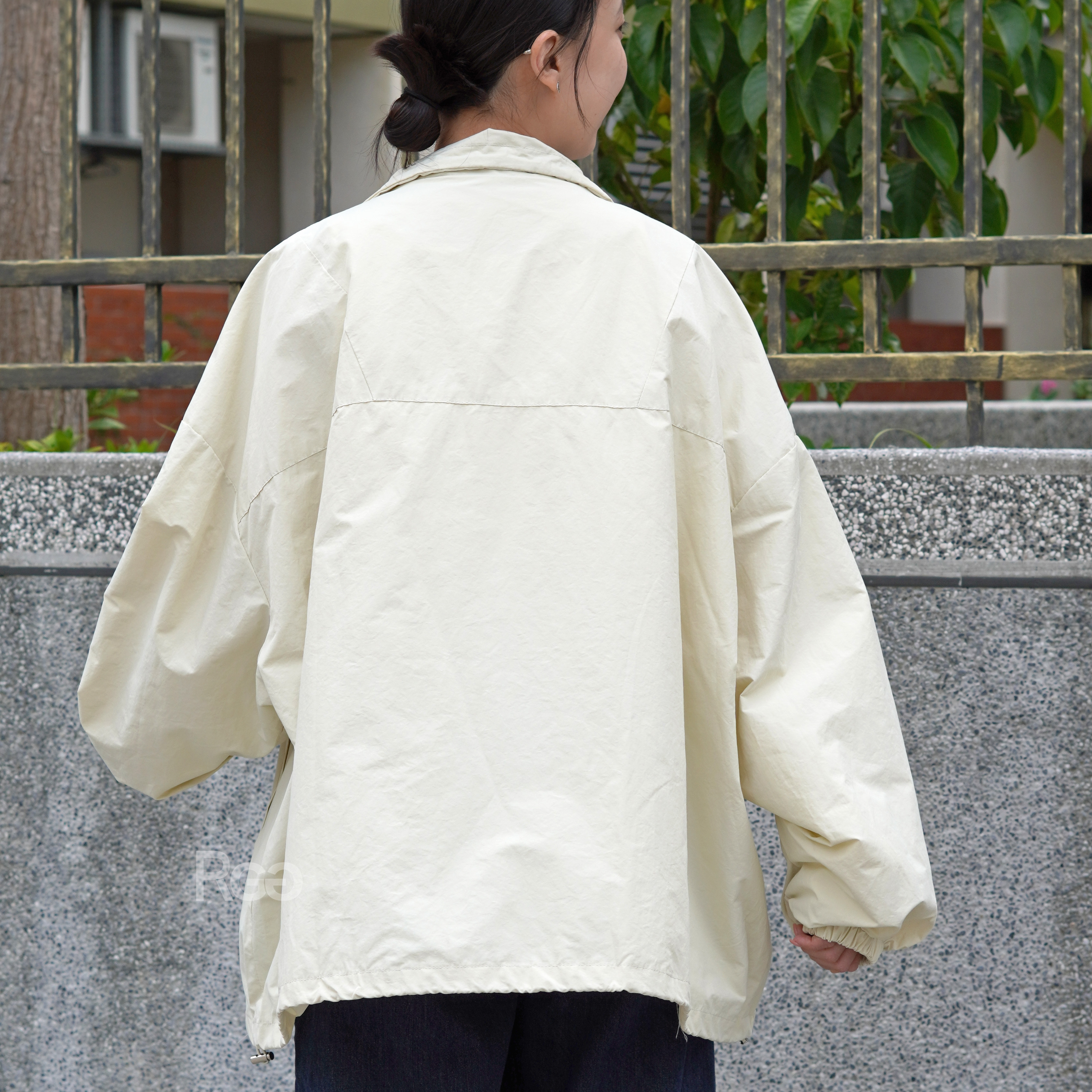 女模穿著寬版風衣拉鍊外套米色