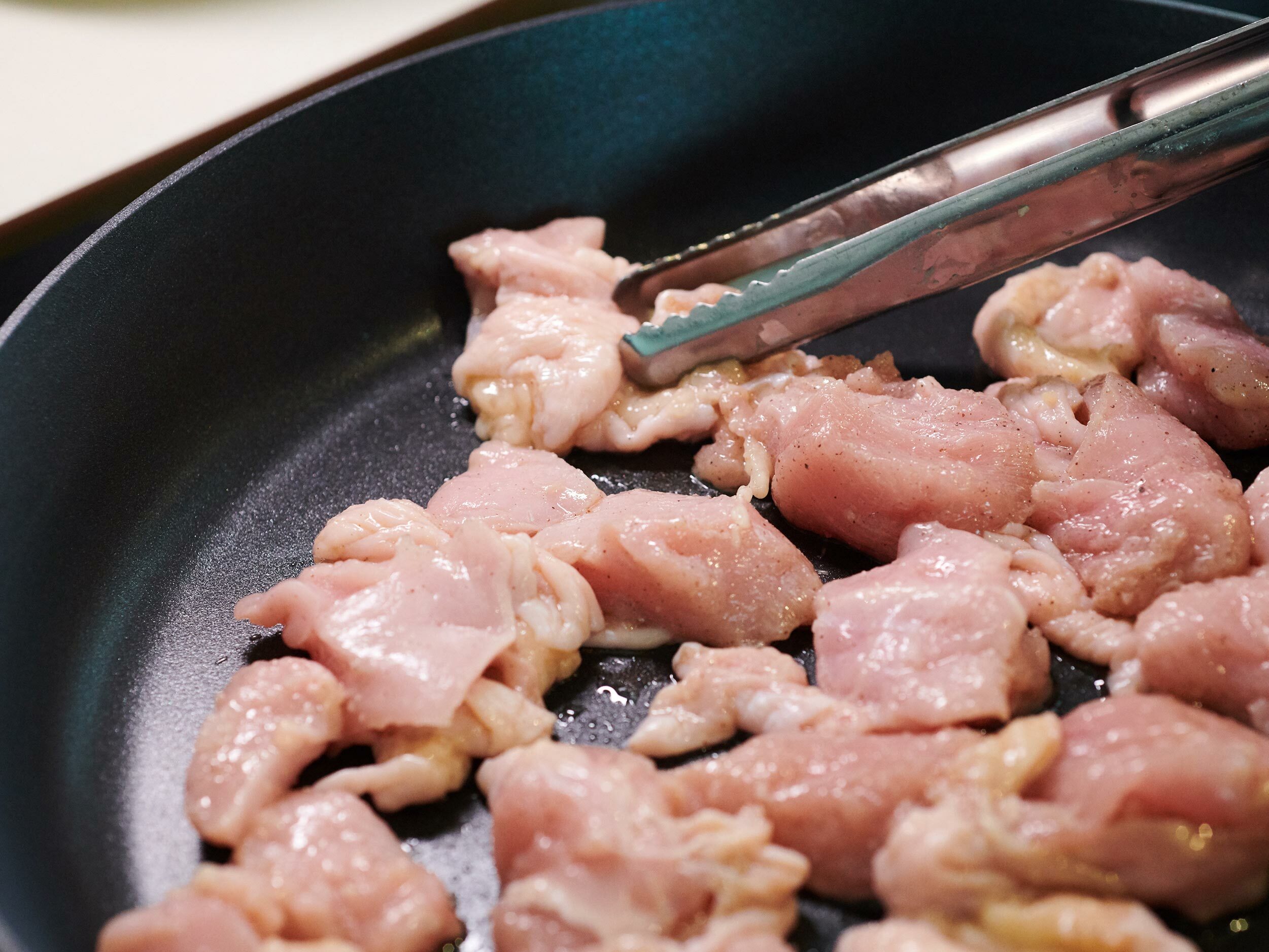 將雞肉和調味料一起放入平底鍋裡以中火加熱