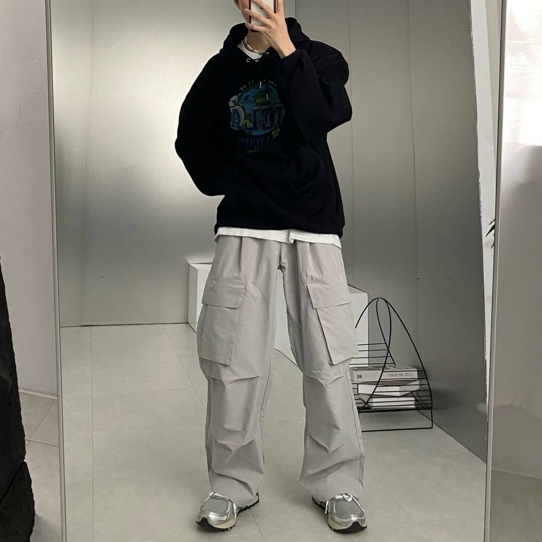 男模著側邊大口袋抓皺工裝寬褲灰色鏡子實著照