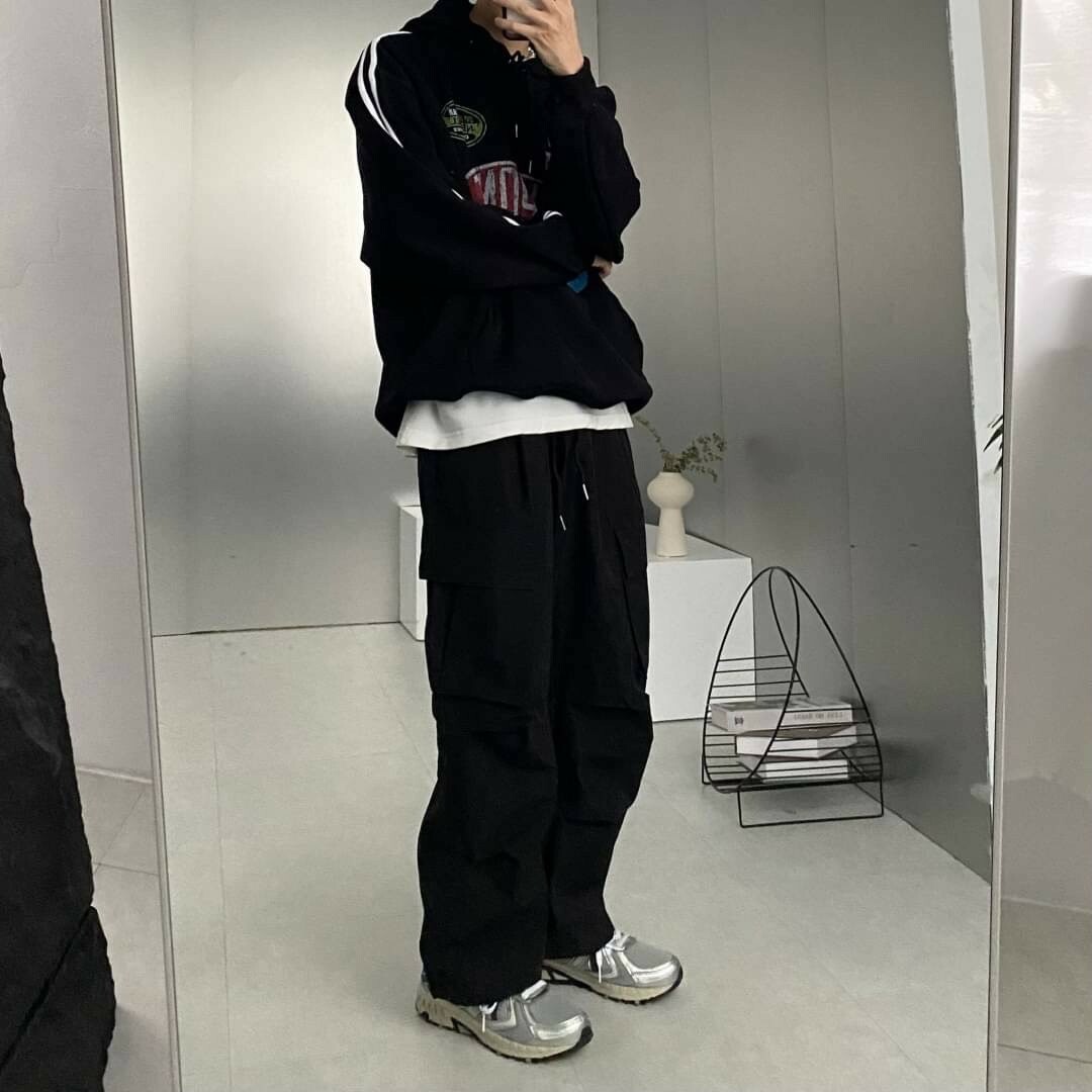 男模著側邊大口袋抓皺工裝寬褲黑色鏡子實著照