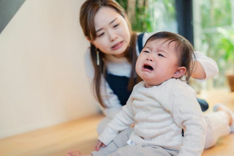 一位媽媽和一位因脹氣在哭鬧的寶寶