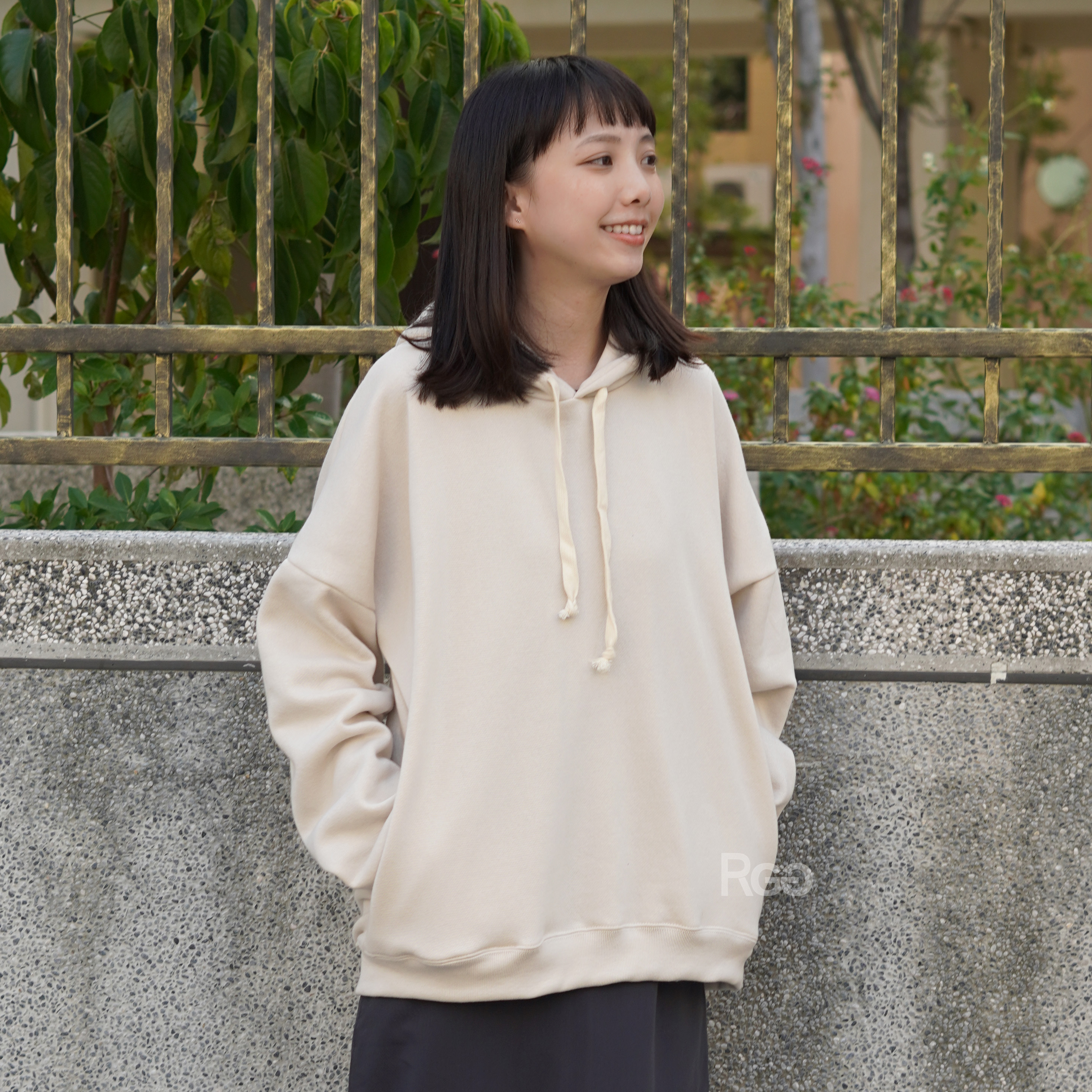 女模穿著訂製款台灣製純棉落肩隱藏口袋帽T奶油米白色