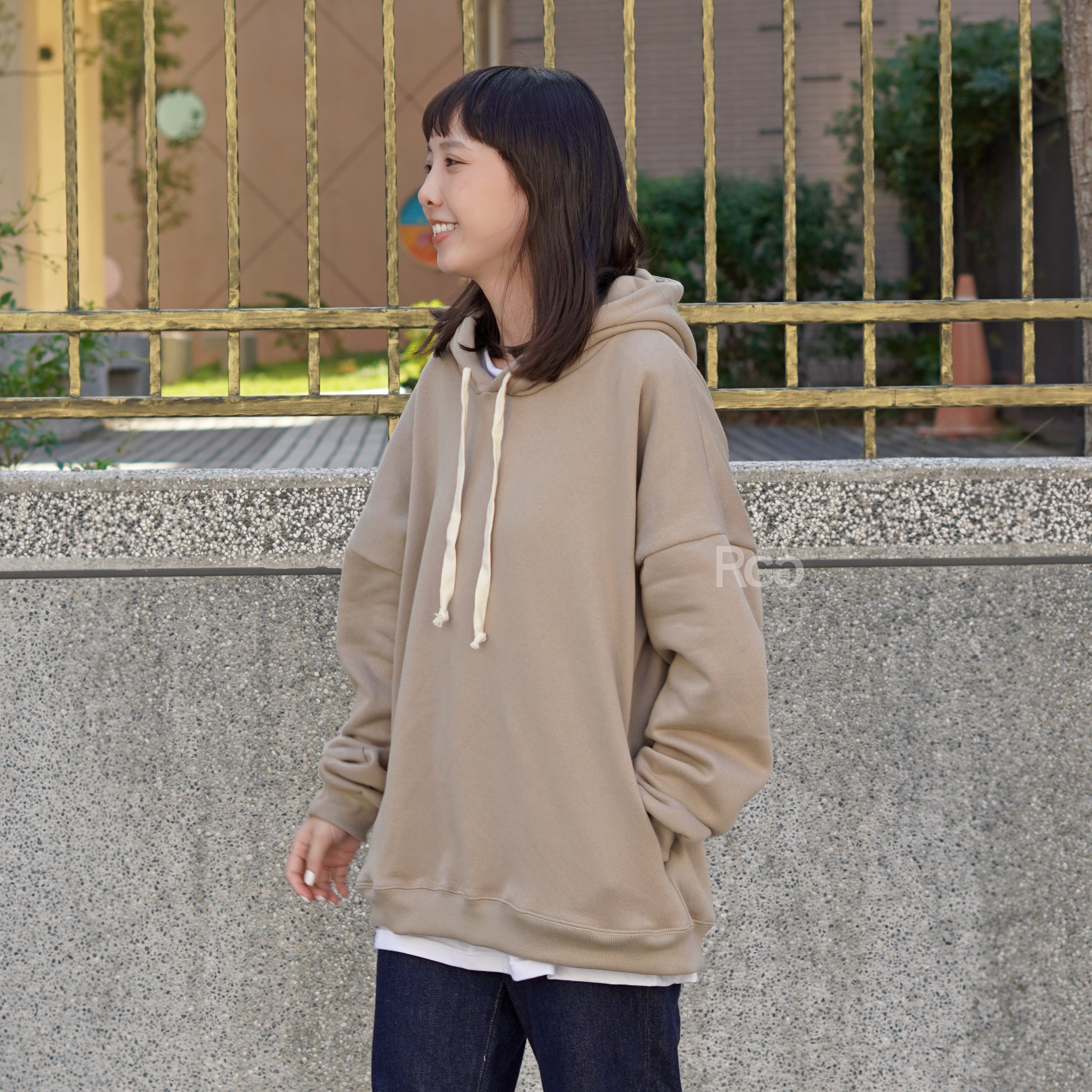 女模穿著訂製款台灣製純棉落肩隱藏口袋帽T燕麥奶茶色