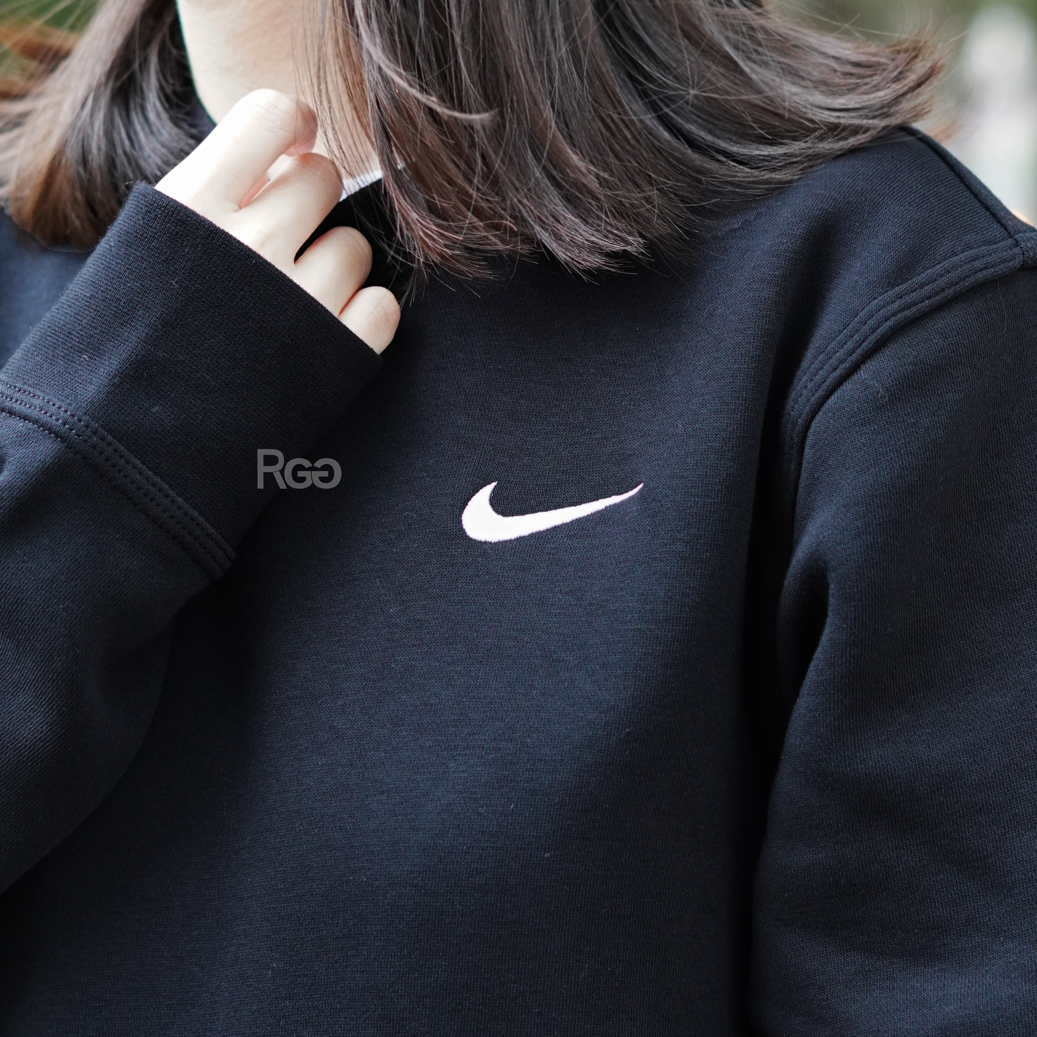 女模穿著Nike Club Fleece 單勾內刷毛大學T黑色細節照